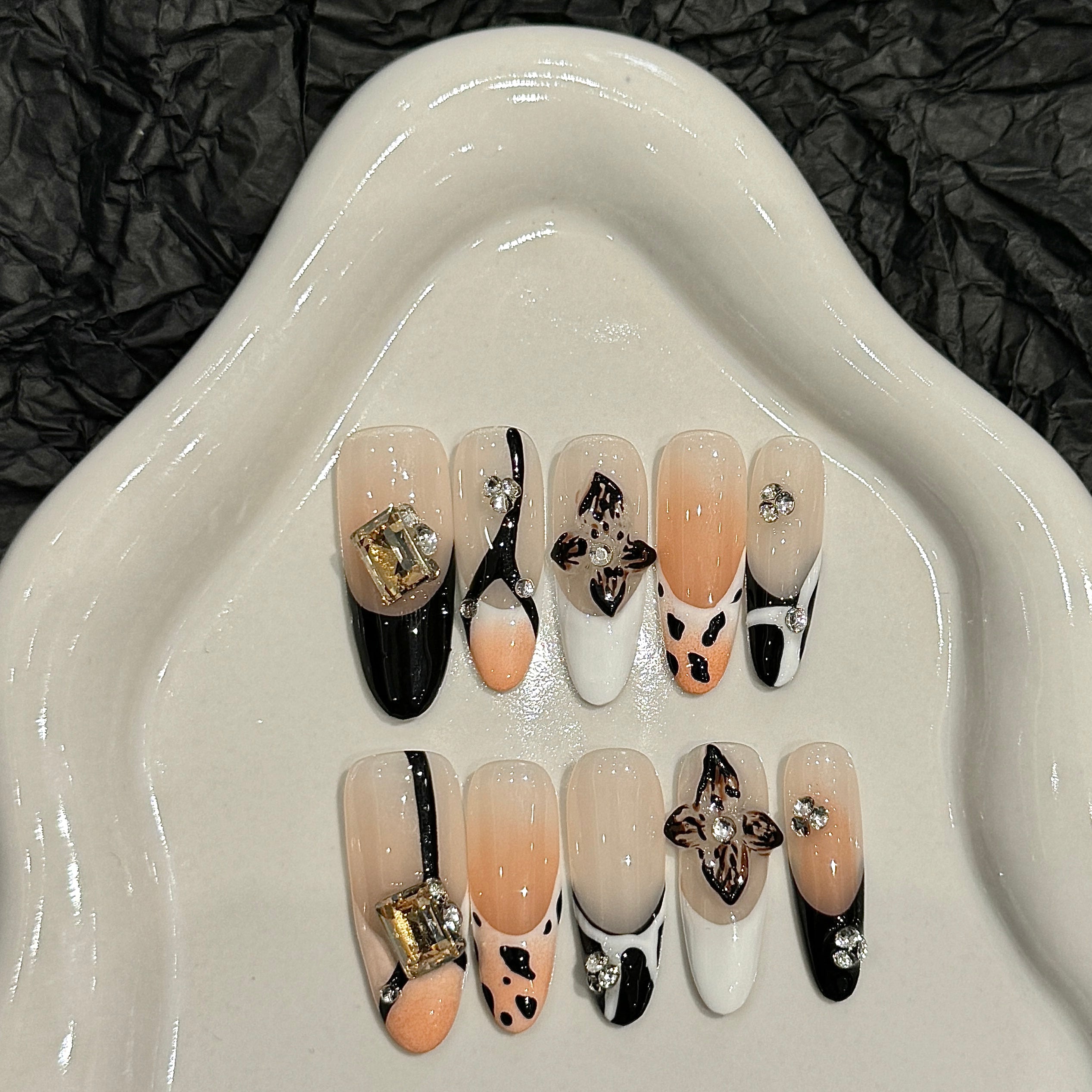 The elegant style of nude and black colors, with floral nail art