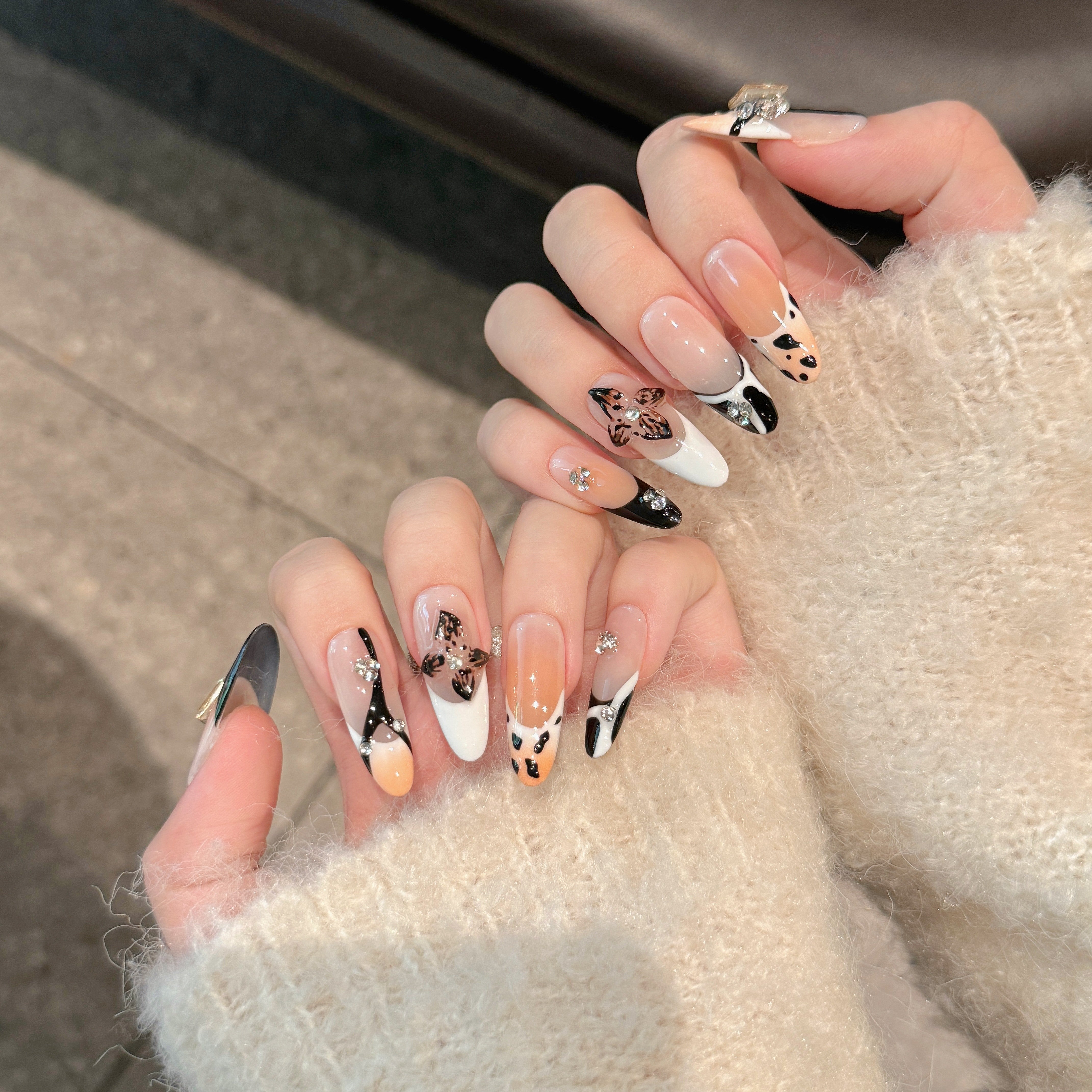 The elegant style of nude and black colors, with floral nail art