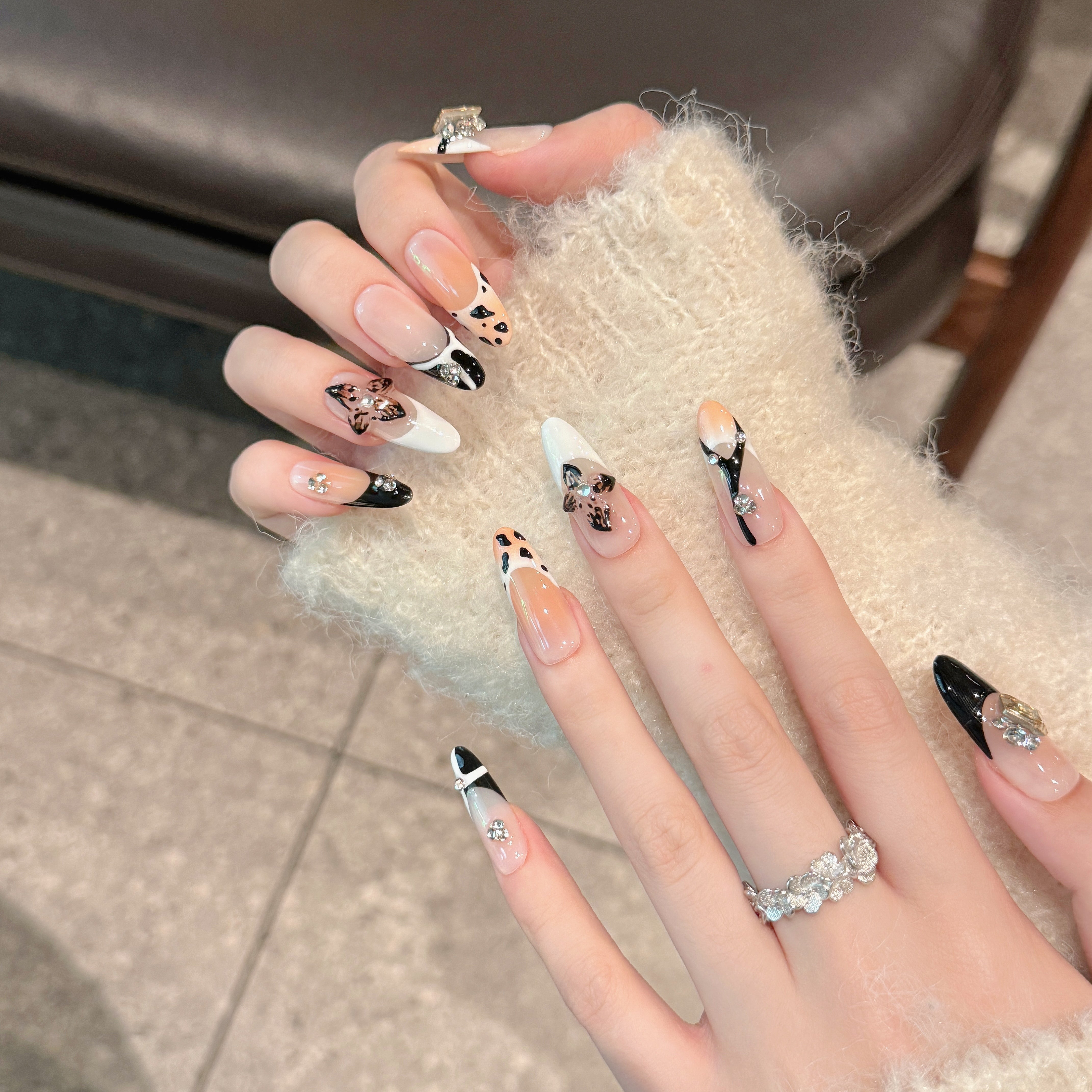 The elegant style of nude and black colors, with floral nail art
